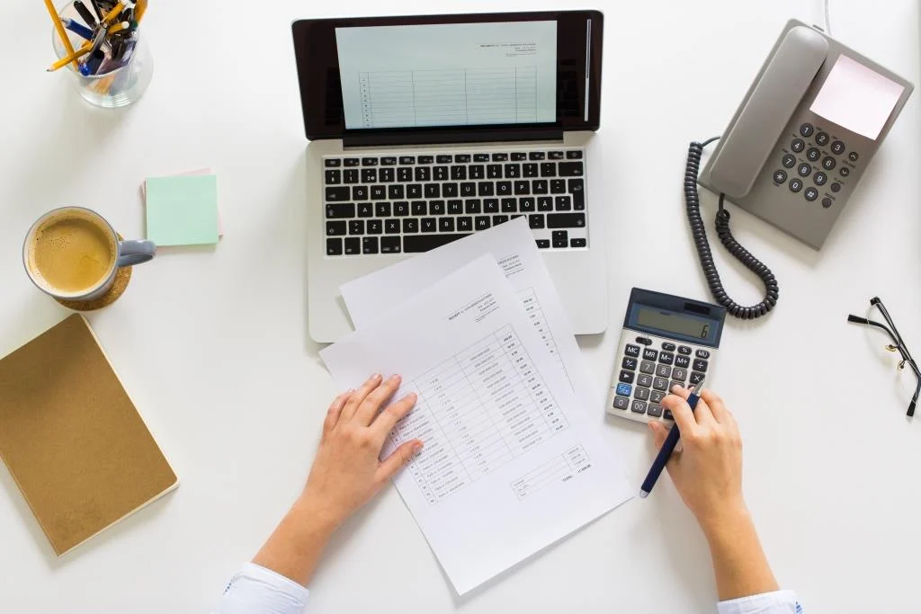 hands-with-calculator-and-papers-at-office-table-PUKBPBW